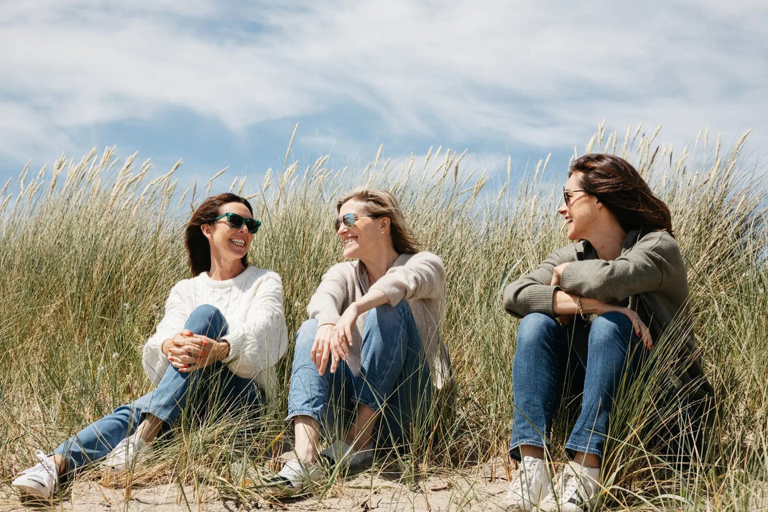 SISTERLY founders Aoife, Jenny and Louise sitting together in the dunes on the beach